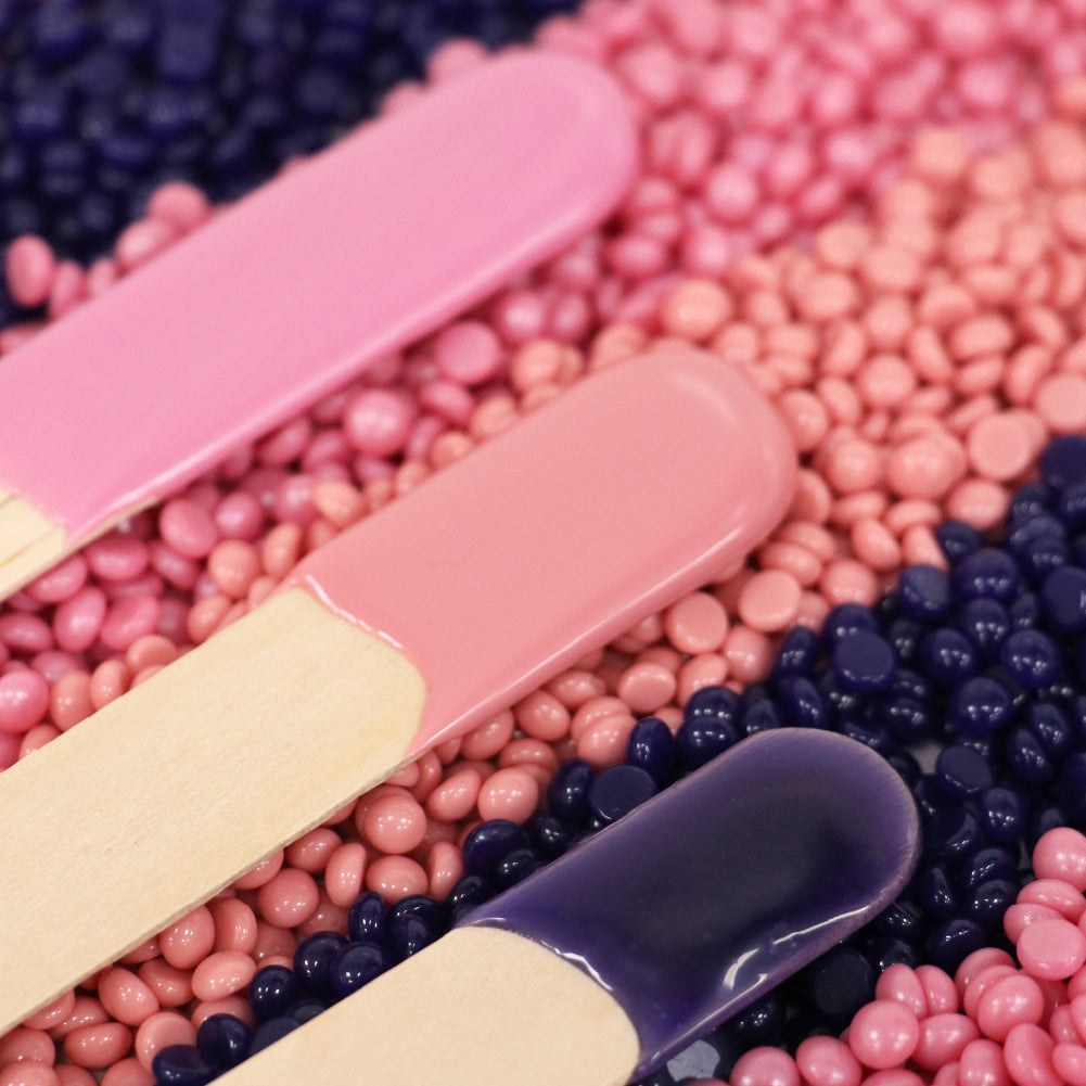 Photo of various LYCON Hot Wax Beads in a row with spatulas sitting on top