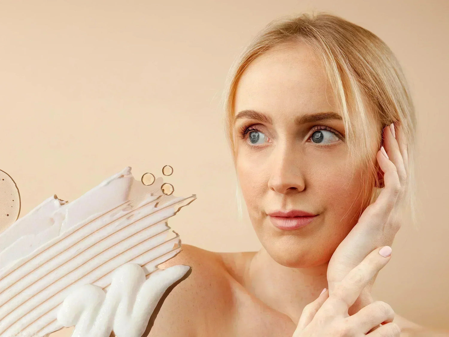 A woman smiling and touching her face surrounded by swatches of LYCON Skin products