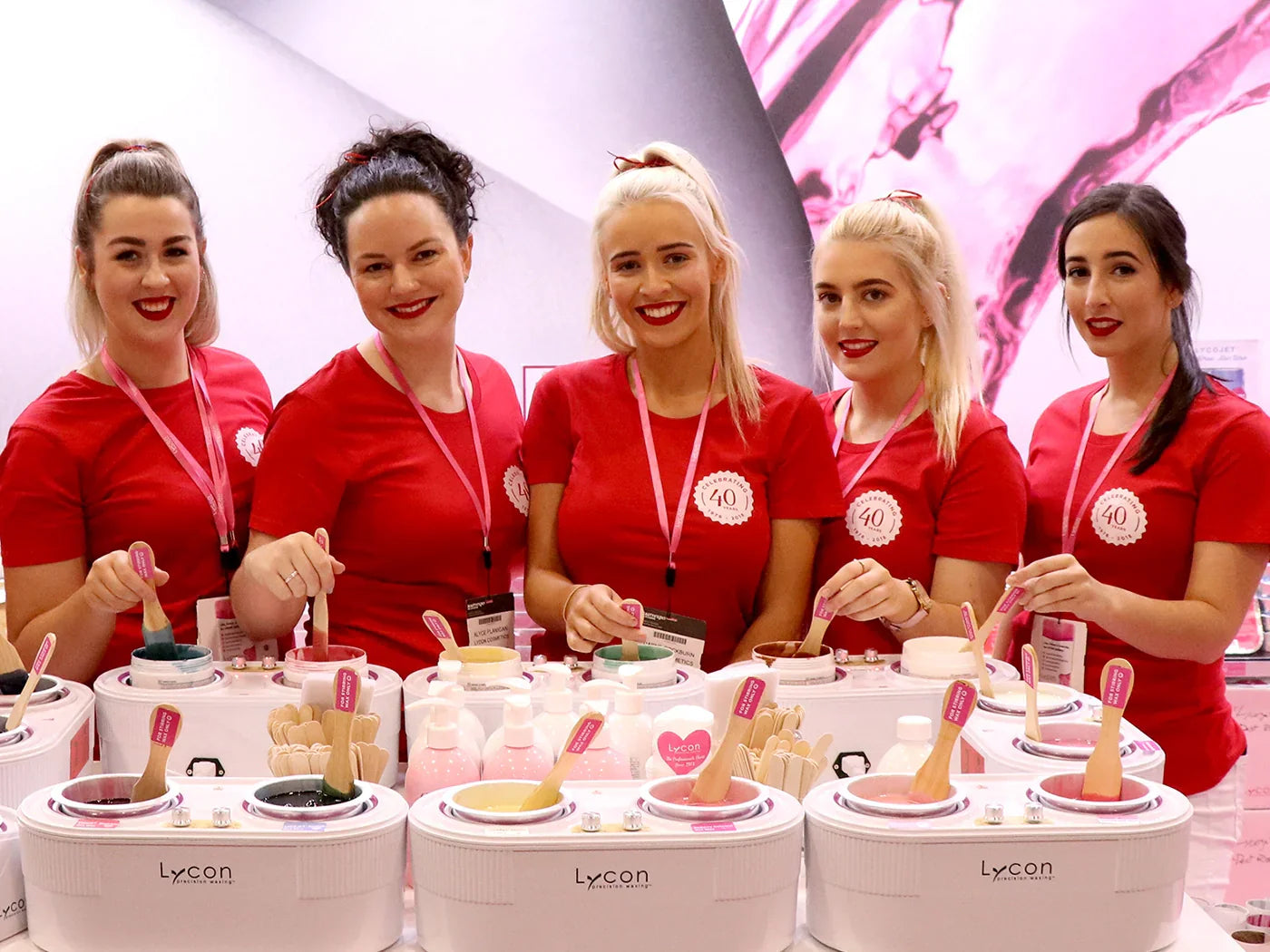 A photo of the LYCON Cosmetics team smiling in front of wax heaters at Beauty Expo Melbourne 2018